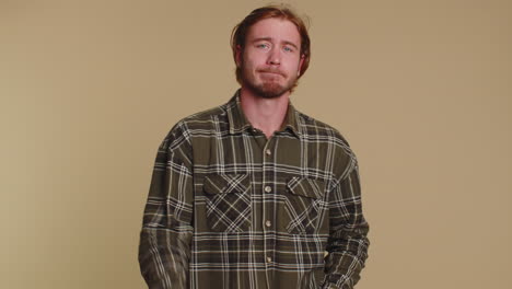 trendy young adult man praying, looking upward and making wish, asking god for help, begging apology