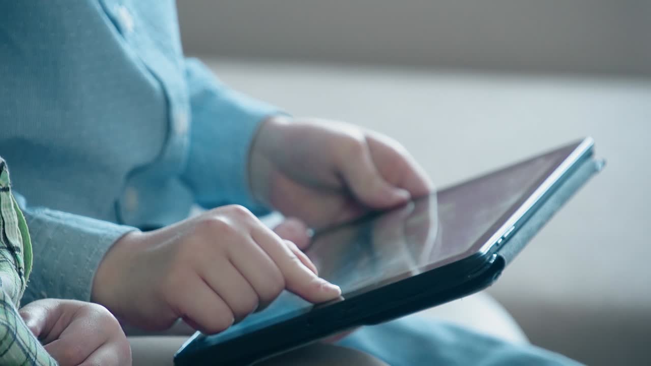 어린 소년 은 태블릿 pc 에서 놀고 있다