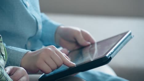 little boy plays on a tablet pc