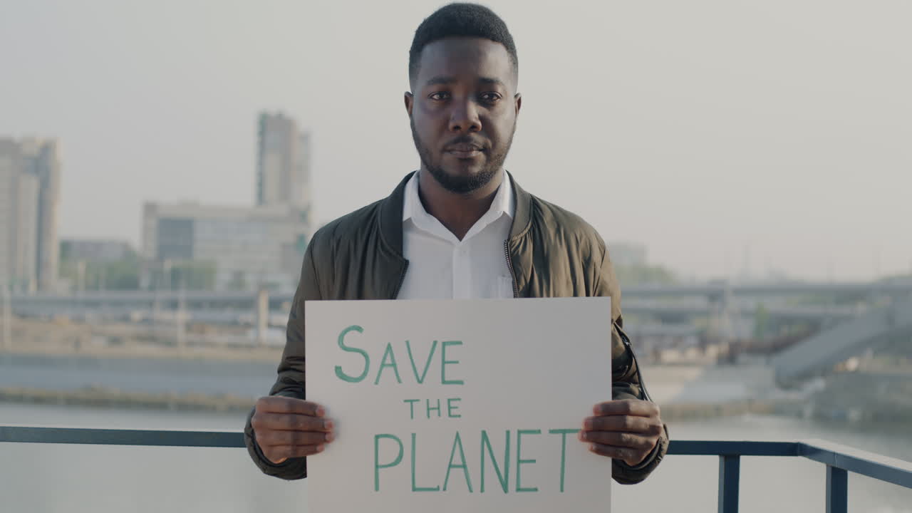 Mann hält Schild mit der Aufschrift „Rettet den Planeten“