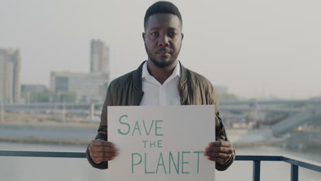 Man Holding 'Save The Planet' Sign