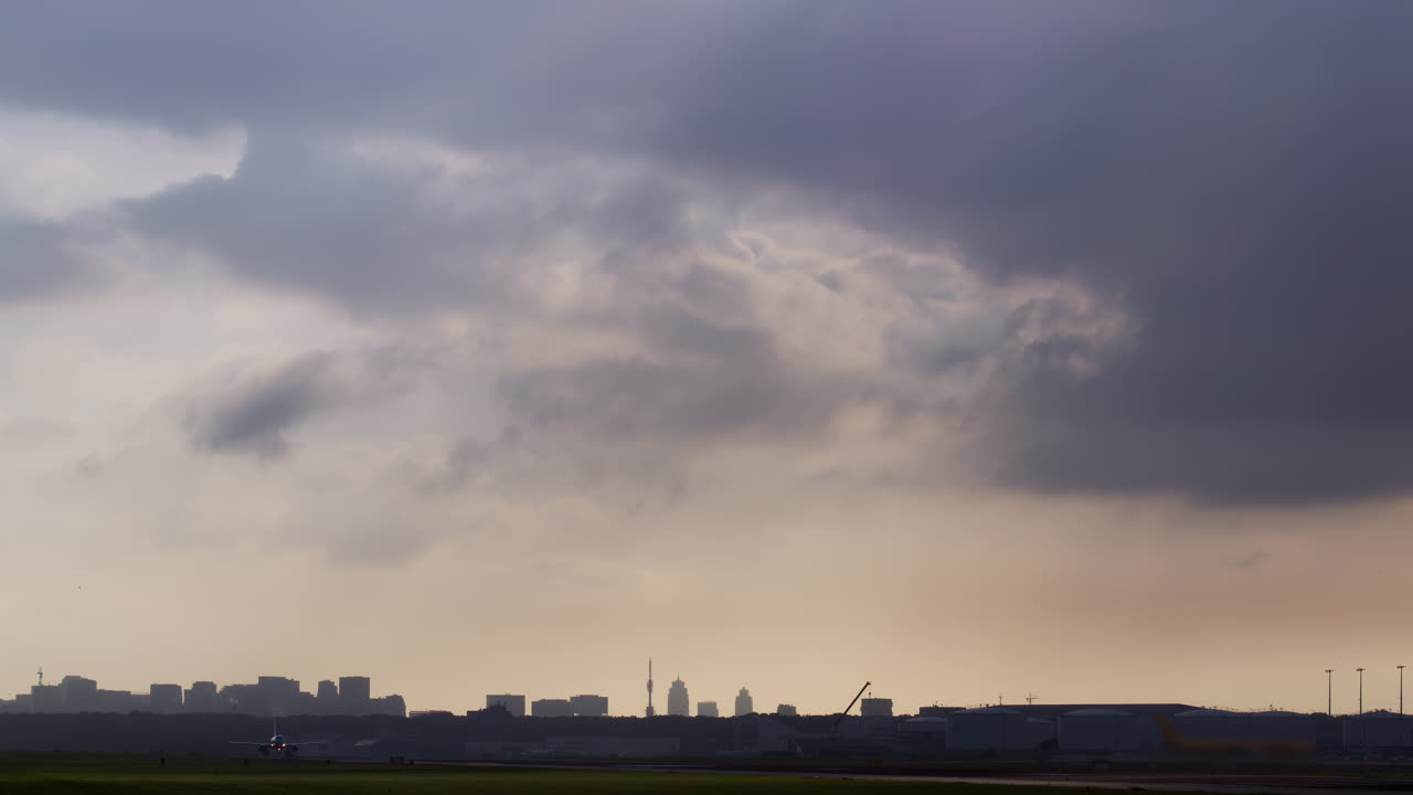 해가 지는 동안 도시 위를 떠나는 비행기