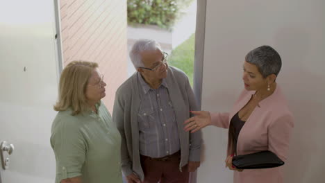 real estate agent with senior couple visiting house for buying