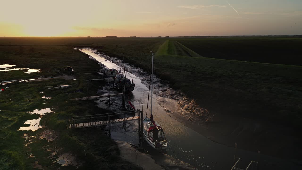 barcos de vela atracados en un estuario iluminado por el sol con luz solar dorada