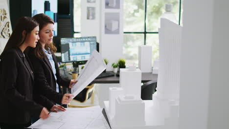 architects team studying 3d printed building model in office