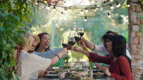 friends making toast celebrating dinner party drinking wine eating mediterranean food sitting at table enjoying beautiful summer day outdoors 4k footage