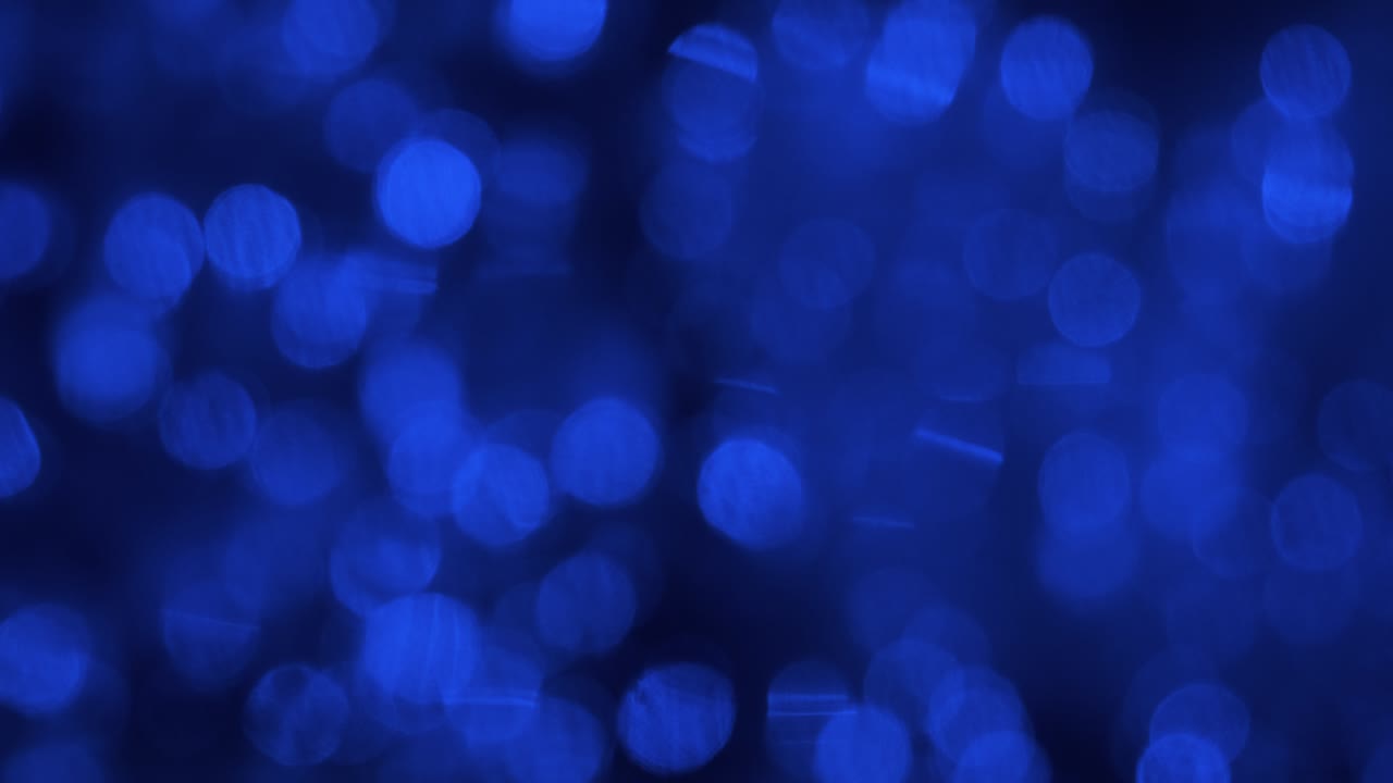 movimiento caótico de luces azules borrosas reflejadas en el agua.