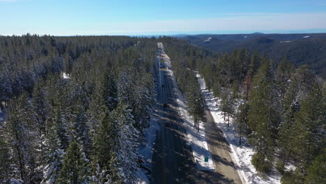 aerial view tracking traffic along the the i-80 in the snowy mountains of california, usa