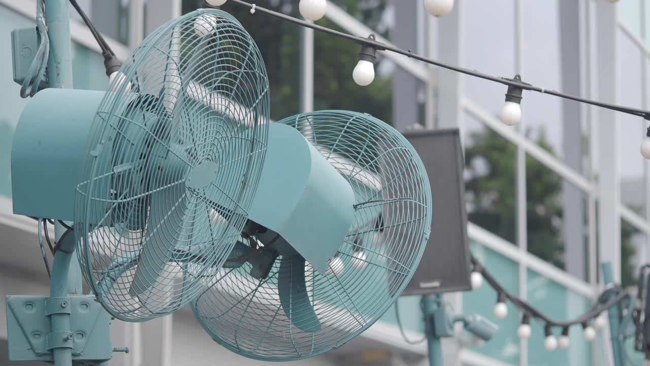 Two Industrial Fans and String Lights on an Outdoor Patio