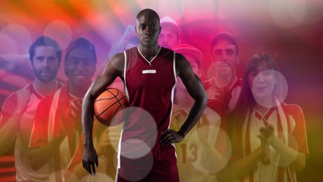 Spots-of-light-over-portrait-of-african-american-male-basketball-player-against-fans-cheering