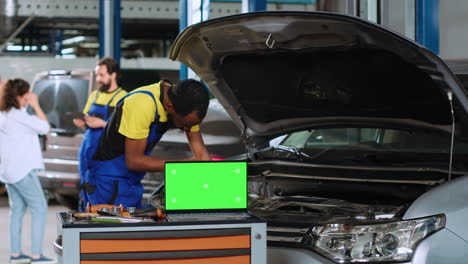 Car-engineer-next-to-chroma-key-laptop