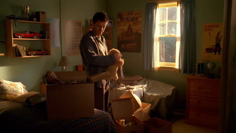 man packing a teddy bear in a bedroom