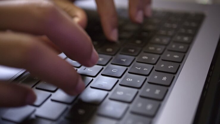 Female professional working from home, typing quickly on her laptop, focused on the screen while handling digital documents and applications, representing productivity in a remote work environment