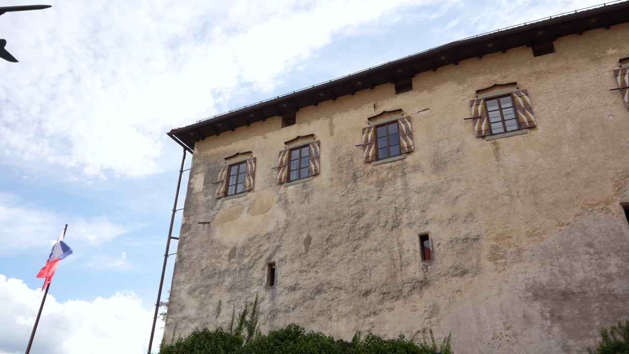 Pan shot inside Bled Castle during the day with flag waving in Bled, Slovenia