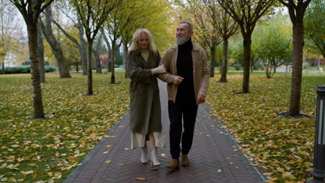 wide shot of senior romantic couple walking in relaxed atmosphere in park.