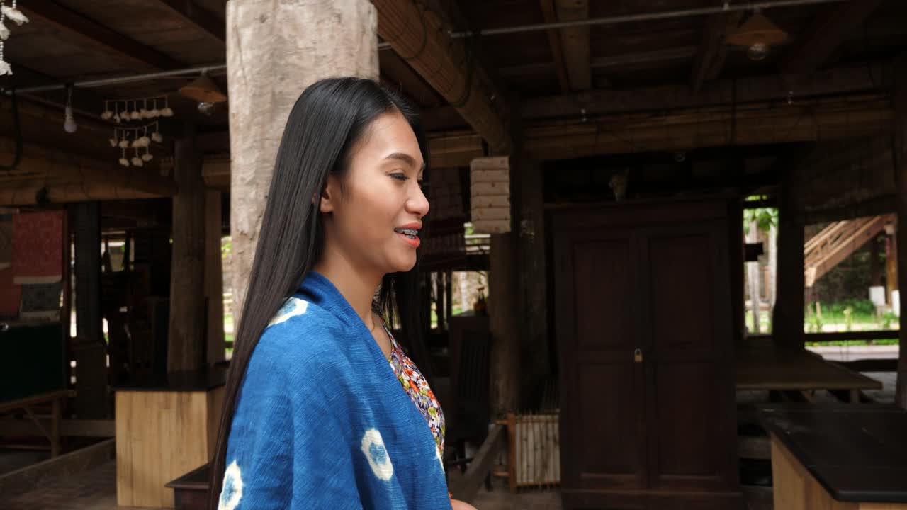 Smiling Asian Woman in Traditional Attire at a Rural Marketplace