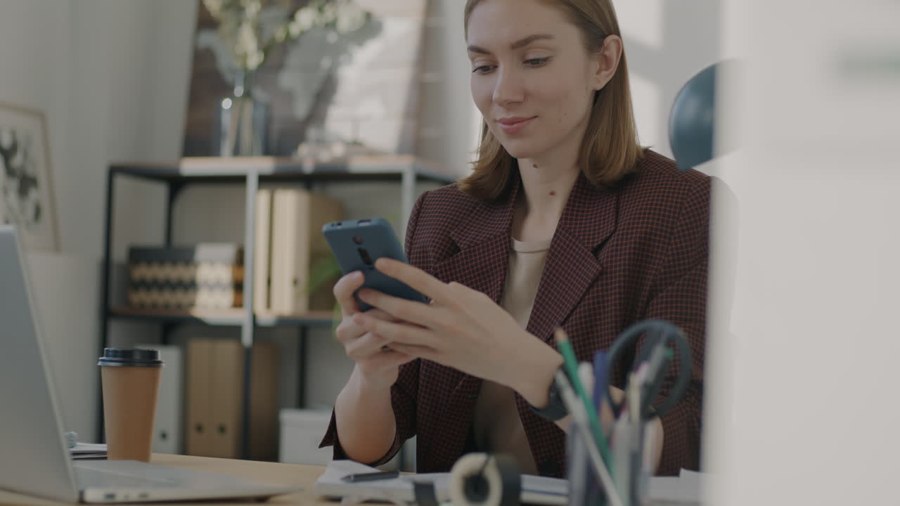 Woman working on smartphone in office