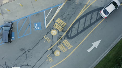 fotografía cenital giratoria de autos que ingresan para conducir a través del carril en un restaurante de comida rápida antena de drones