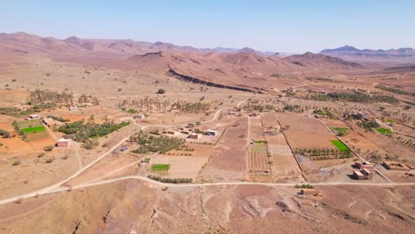 carretera de sobrevuelo aéreo y campos desérticos en marruecos con campos verdes en crecimiento - hermosa cordillera roja en el fondo - marruecos, áfrica