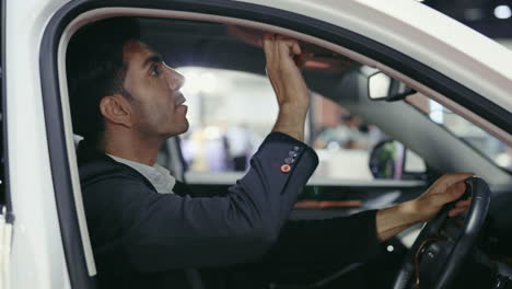 man adjusting car interior