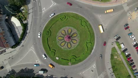 4k aerial view of roundabout road with circular cars in small european city at sunny day