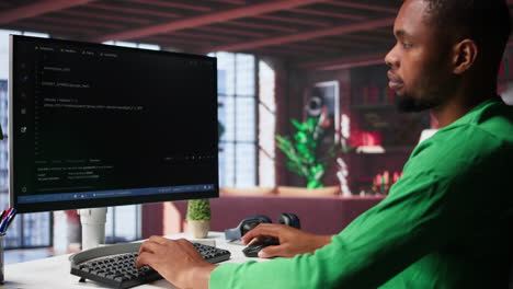male programmer types code on computer and running script