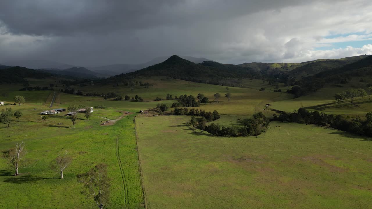 vistas aéreas sobre tierras de cultivo en lamington en el borde escénico con la lluvia cayendo en la distancia, queensland, australia