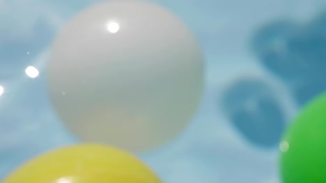 the balls float in the water. sun glare.