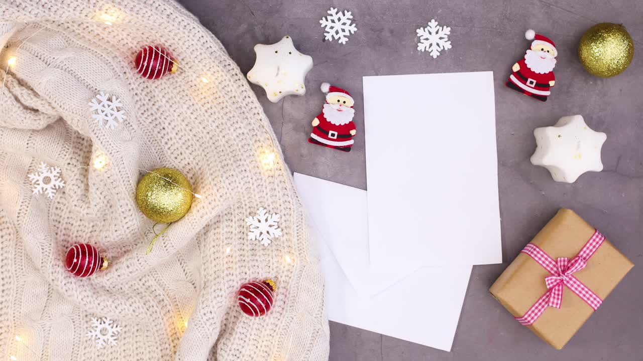 decoración de invierno con ropa de punto, luces parpadeantes, adornos navideños y papel para texto.