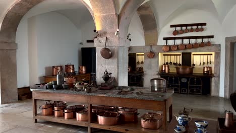 old historic kitchen at pena palace in sintra with pan and pot of copper, panning shot