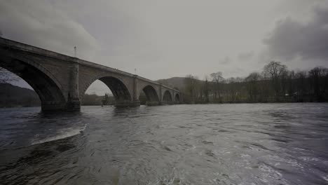 fast flowing water under dunkeld bridge in scotland