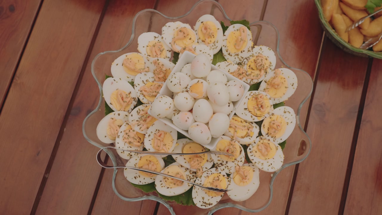 Boiled eggs sliced and whole arranged on platter with herbs for buffet catering event