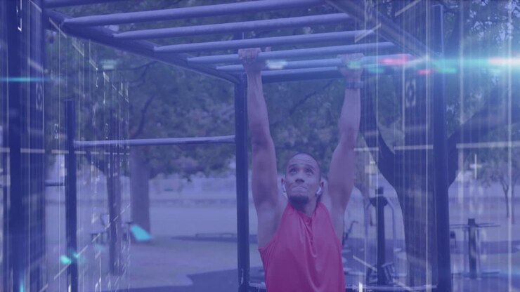 Animation of lights and data processing over male athlete exercising on monkey bars outdoors
