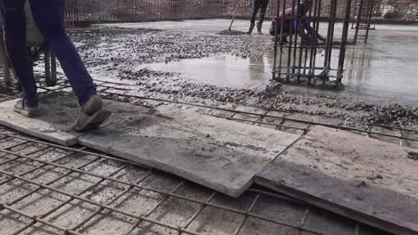 construction workers pouring concrete using the wheelbarrow or concrete trolley