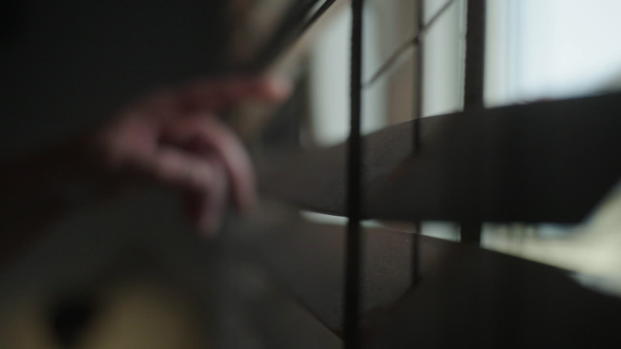 Hand touching window blinds