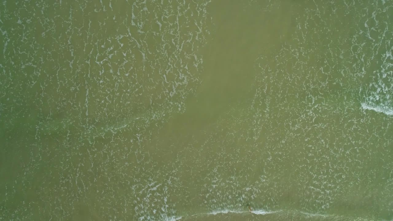 plano cenital con zumbido de olas rompiendo en el mar, hermosa textura y espuma de las olas rompiendo, luz perfecta