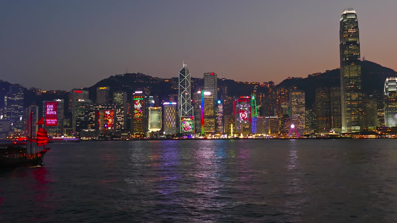 un barco de chatarra chino en el puerto de victoria por la noche.