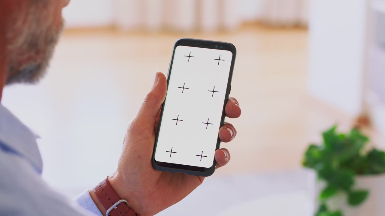 Uomo che tiene in mano uno smartphone con indicatori di tracciamento sullo schermo