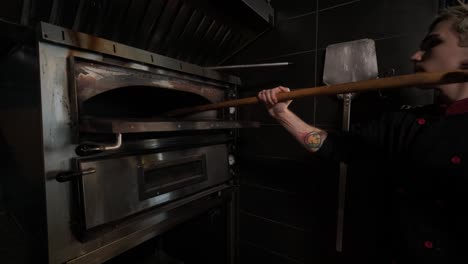 chef usando el horno de pizza