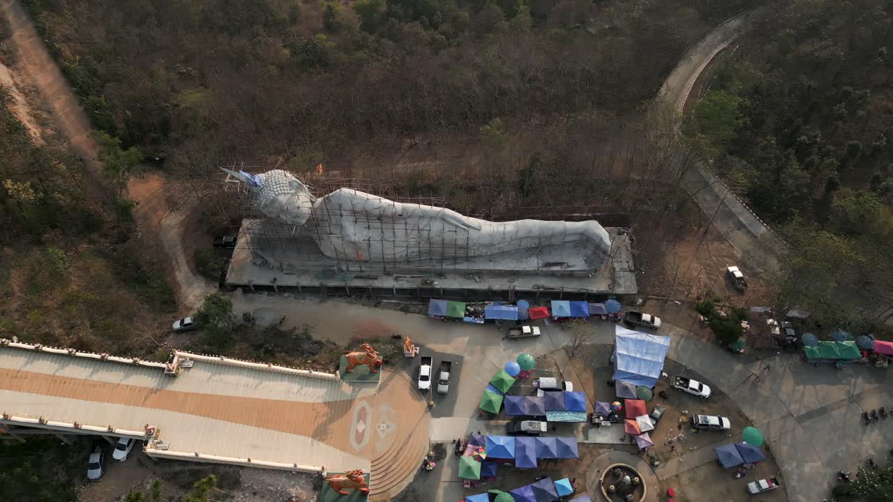 Aerial View of a Large Reclining Buddha Statue Under Construction with Surrounding Market Stalls