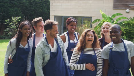 Group-Portrait-Of-Men-And-Women-Attending-Cookery-Class-Relaxing-Outdoors