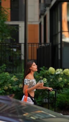 woman walking outdoors with drink