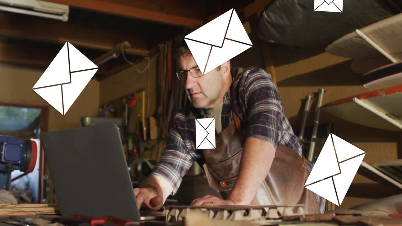 Animation of envelope icons over caucasian man using laptop