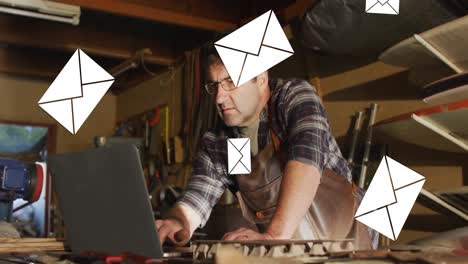 animación de iconos de sobres sobre hombre caucásico usando computadora portátil