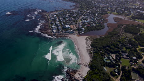 aerial view of holiday town onrus and lagoon as waves crash onto beach