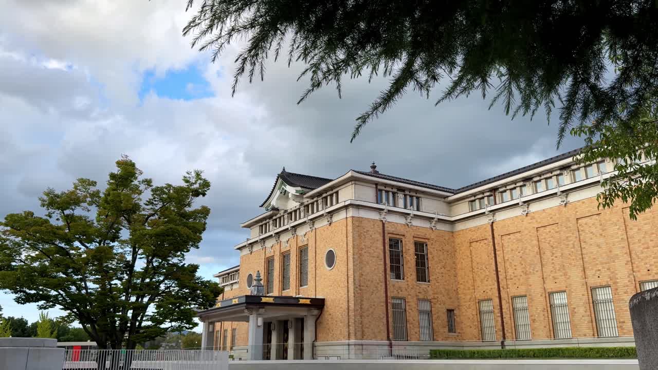 Historic Kyoto building with trees and cloudy sky, peaceful ambiance