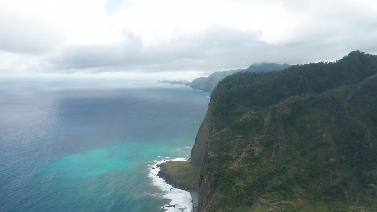 Breathtaking cliffs of Madeira with white clouds and blue water of Atlantic