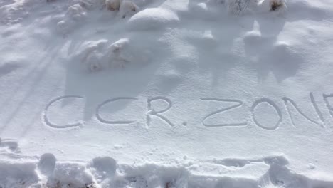 the word ccr zone written in the snow on hilly area with mountain in the background