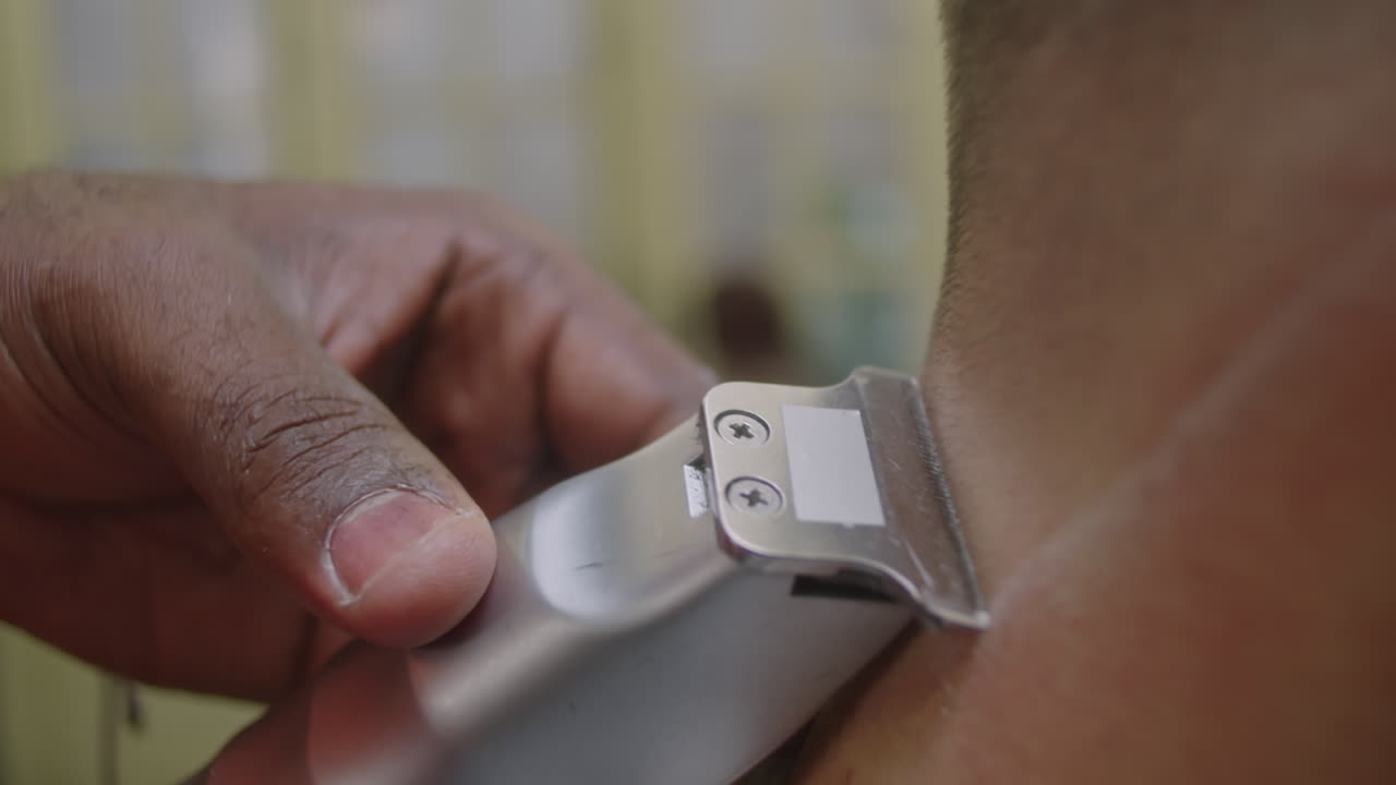 Hands of Barber Shaving Neck Hair of Man with Electric Razor
