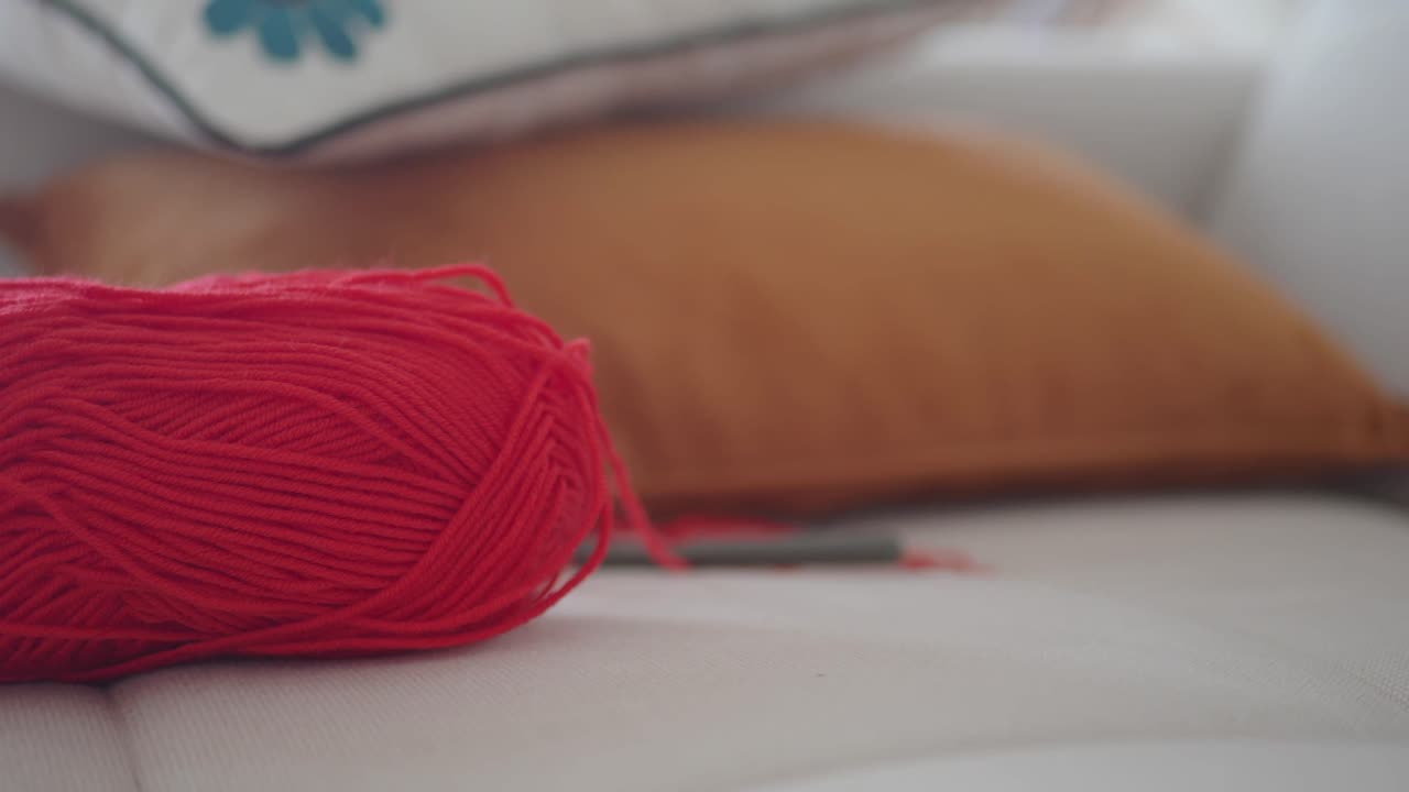 Ball of Red Yarn on a Sofa